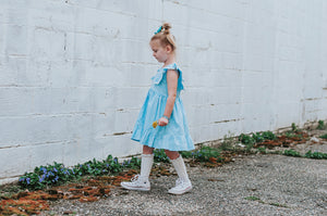 Little Girl's Blue Gingham Pinafore Dress with Pom Pom Trim