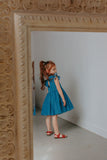 Little Girl’s Chambray Cotton Flutter Sleeve Dress with Keyhole Cut Out and Pom Pom Trim