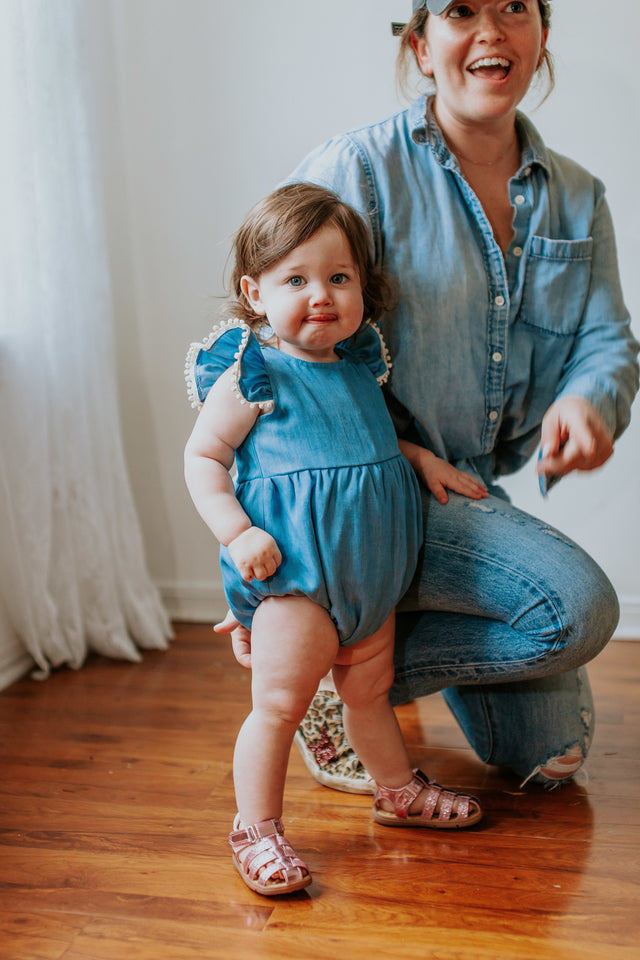 chambray bubble romper with pom pom trim