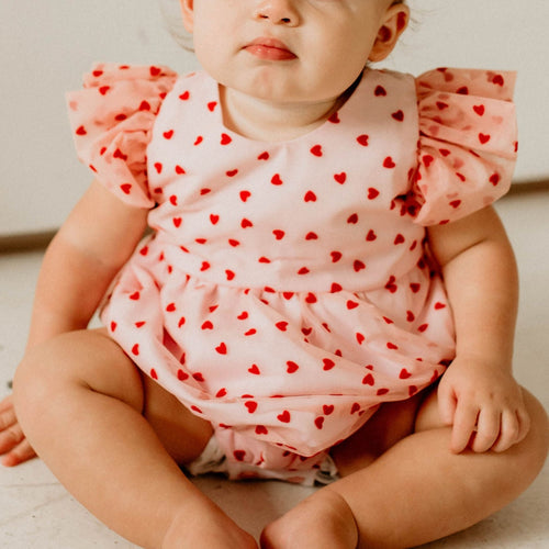 Infant Girl's Pink and Red Tulle Hearts Valentine's Day Bubble Romper. The cutest little girls Valentine's Day special occasion dress for your favorite valentine! If you're looking for the perfect baby's first Valentine's Day outfit, this is the one. Make your little girls first Valentine's Day special with the sweetest outfit.