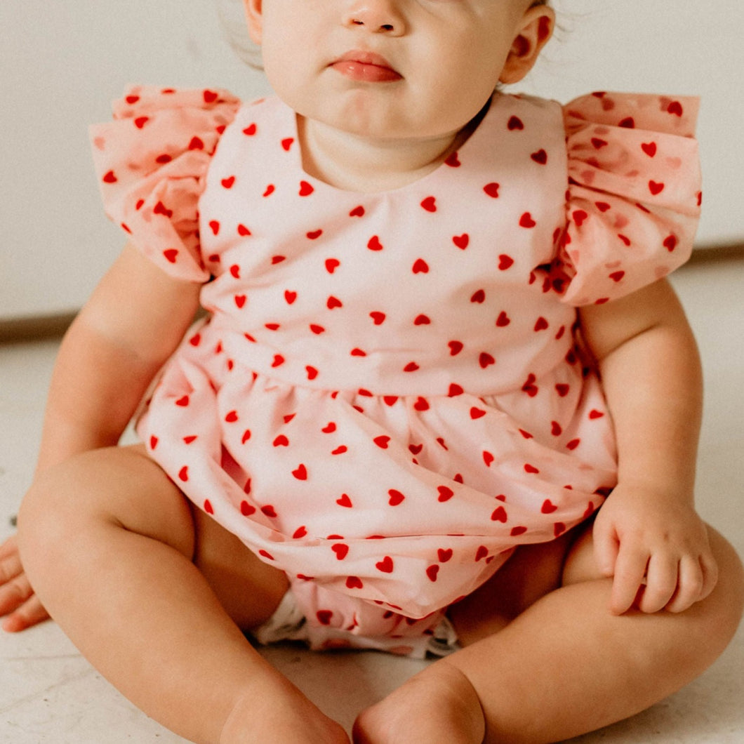 Infant Girl's Pink and Red Tulle Hearts Valentine's Day Bubble Romper. The cutest little girls Valentine's Day special occasion dress for your favorite valentine! If you're looking for the perfect baby's first Valentine's Day outfit, this is the one. Make your little girls first Valentine's Day special with the sweetest outfit.