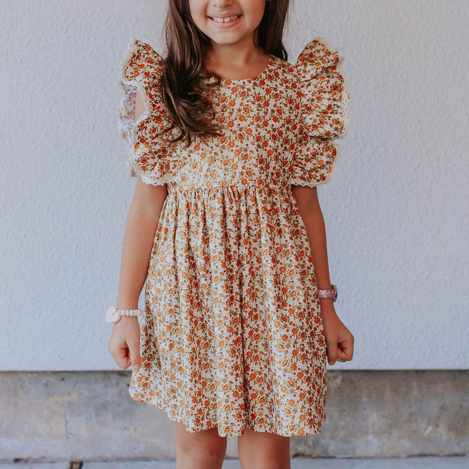 little girl's beige orange and gold calico floral pinafore style dress