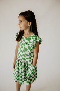 Girl's Green and White Groovy Plaid Print Cotton Jersey Three Pocket Dress. The cutest little girls green and white plaid print cotton jersey dress for any special occasion! This look is perfect for girls who value comfort but also love style; this green plaid dress will be her everyday favorite because of how soft it is. This is the cutest spring dress for girls! If you're throwing a little cutie party this is the dress you need.