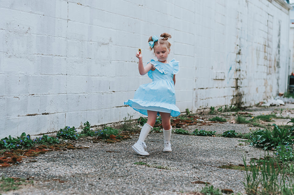 Little Girl's Blue Gingham Pinafore Dress with Pom Pom Trim