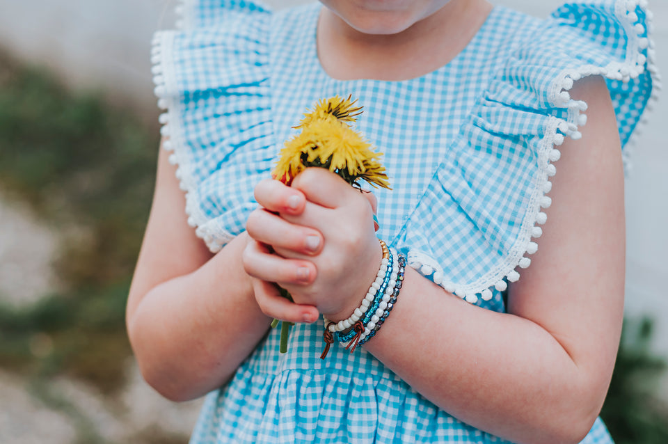 Little Girl's Blue Gingham Pinafore Dress with Pom Pom Trim